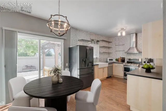 a kitchen with stainless steel appliances granite countertop a kitchen island a stove a table and chairs