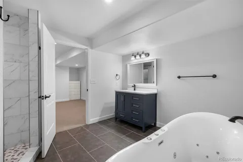 a spacious bathroom with a tub shower and mirror