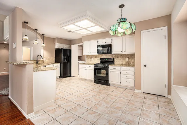 a kitchen with kitchen island granite countertop stainless steel appliances cabinets a sink and a counter top space