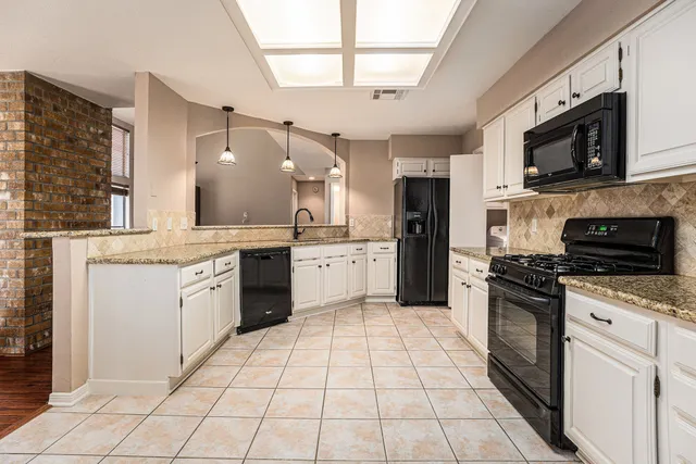 a large kitchen with a stove top oven appliances and cabinets