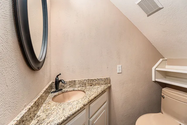 a bathroom with a granite countertop sink and a mirror