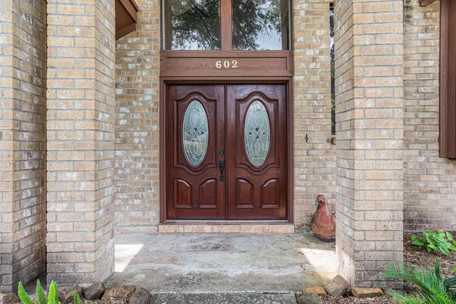 a view of a door with a wall clock and a rug