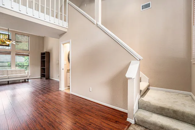 a view of a livingroom with wooden floor and stairs