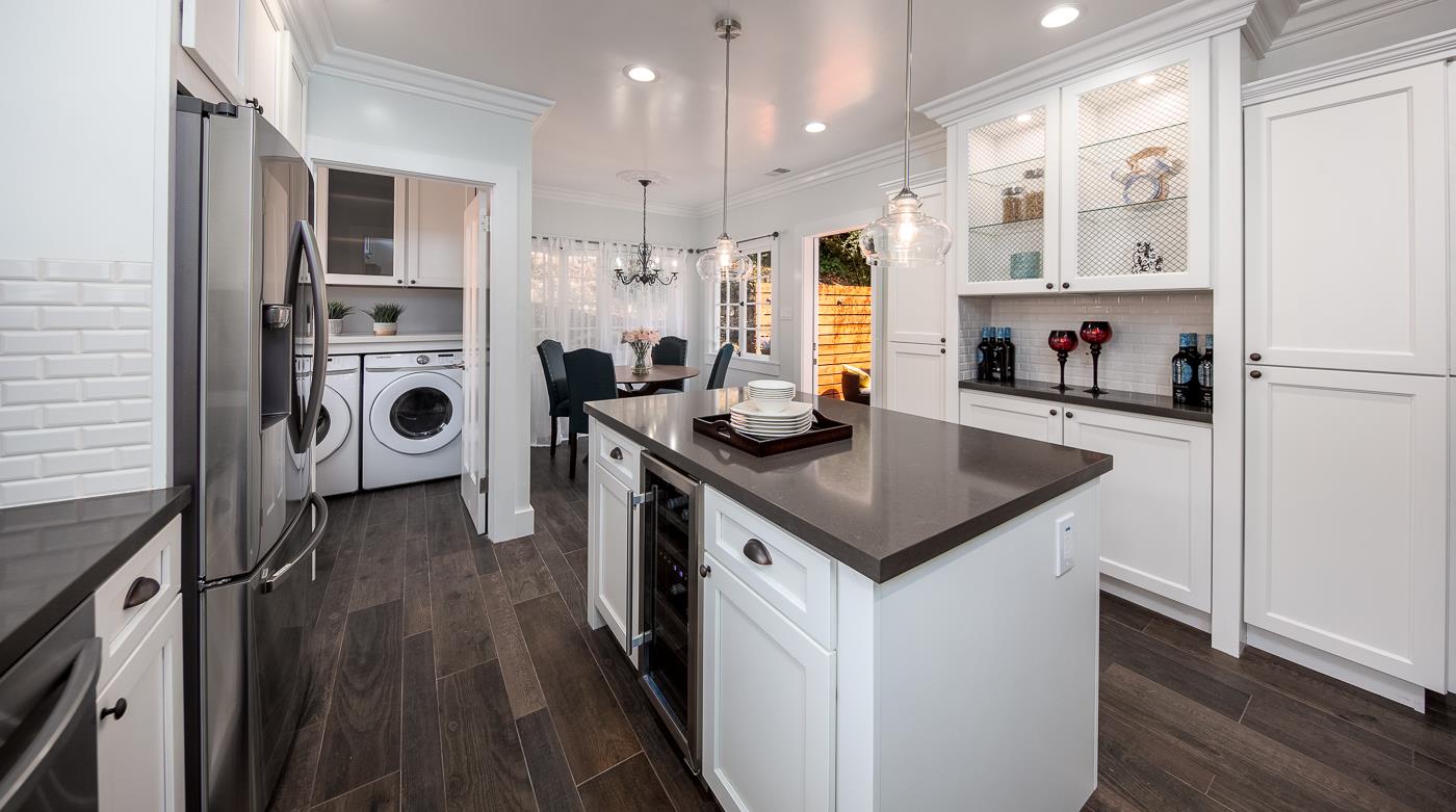 101 Tunnel Road Berkeley, CA 94705 - Photo 14 of 34 a kitchen with stainless steel appliances granite countertop a refrigerator a stove and white cabinets with wooden floor