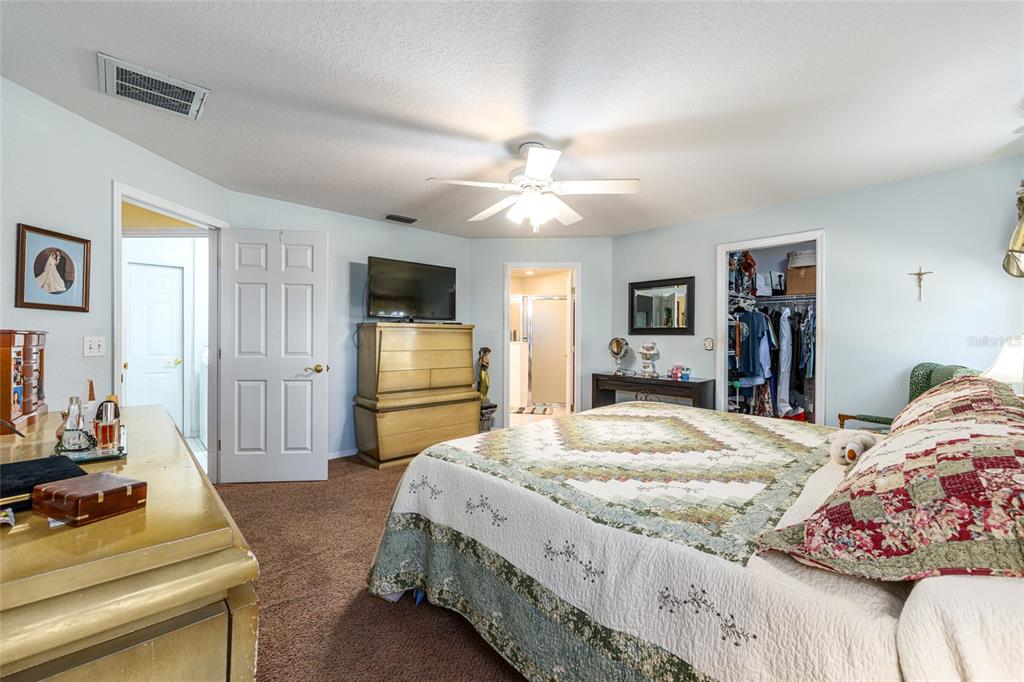 10090 Southwest 78th Court Ocala, FL 34476 - Photo 25 of 52 a bedroom with a bed and a flat screen tv