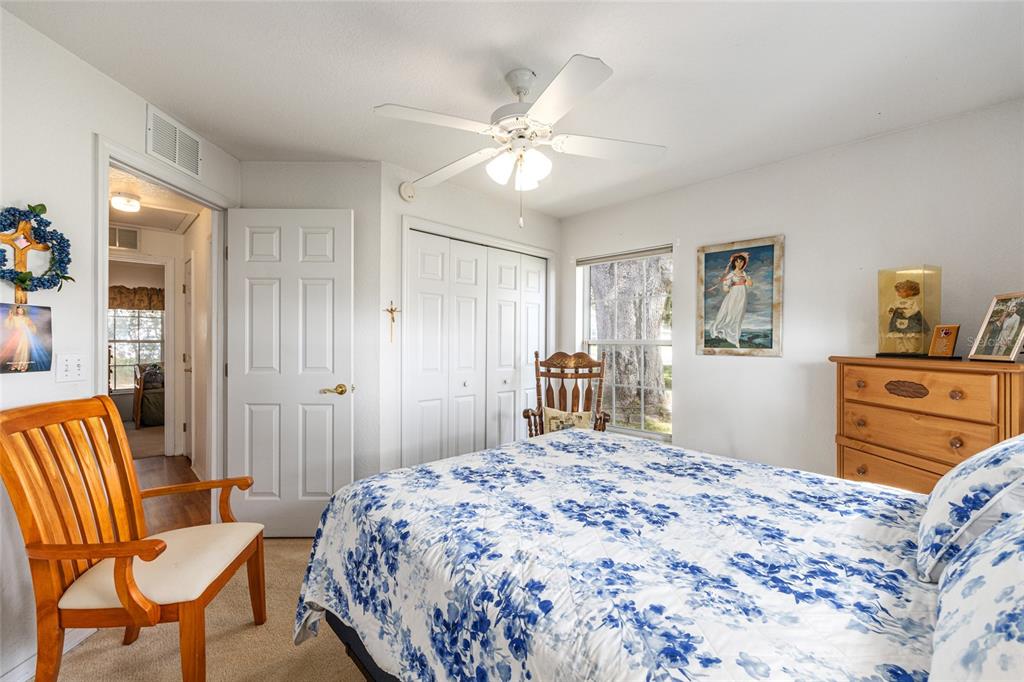 10090 Southwest 78th Court Ocala, FL 34476 - Photo 34 of 52 a bedroom with a bed and a chandelier