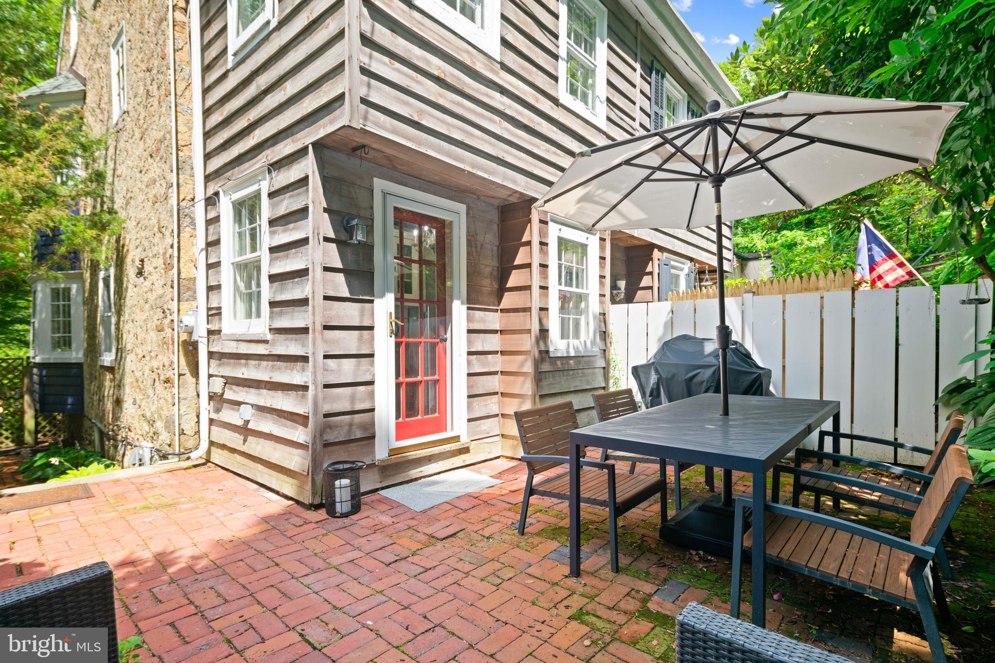 75 West Rose Valley Road Rose Valley, PA 19086 - Photo 28 of 31 a view of a patio with a table and chairs under an umbrella