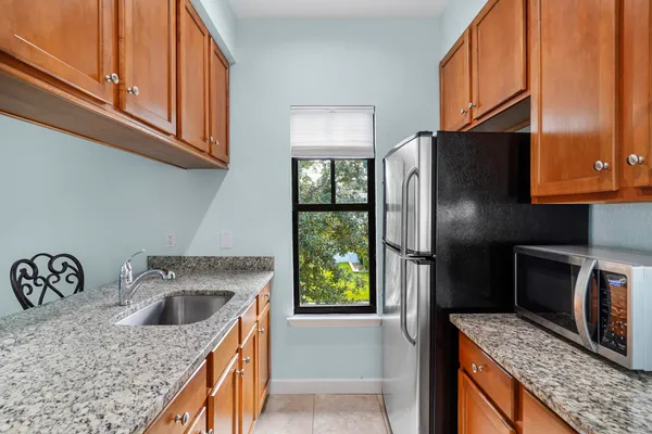 a kitchen with stainless steel appliances granite countertop a refrigerator a stove and a sink with wooden floor