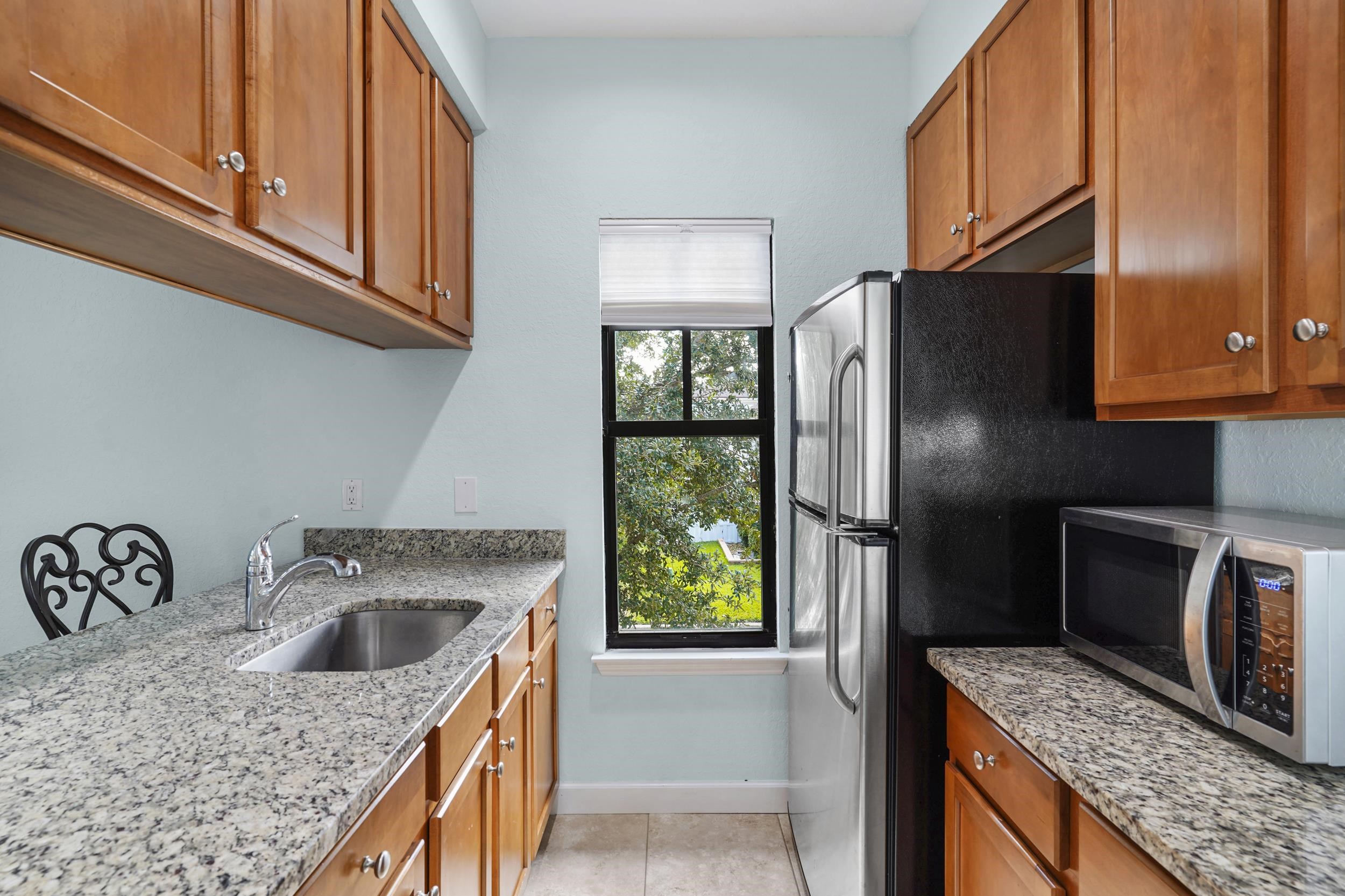 Undisclosed Address St. Augustine, FL 32095 - Photo 12 of 23 a kitchen with stainless steel appliances granite countertop a refrigerator a stove and a sink with wooden floor