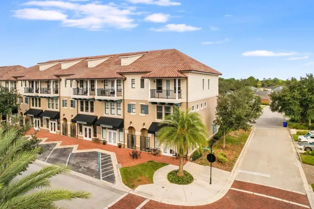 a view of a white house with swimming pool and sitting area