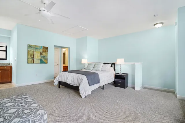 a bedroom with a bed and painting on the wall