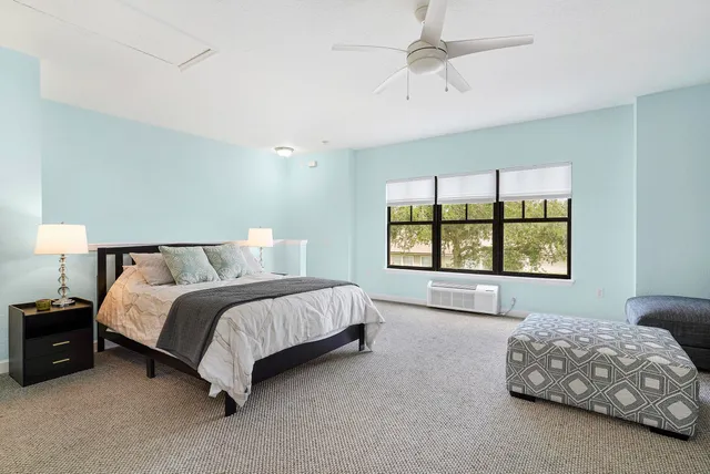 a spacious bedroom with a bed and a window