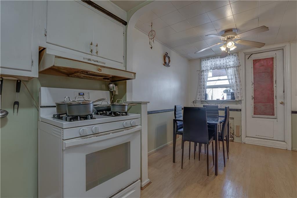 623 Ave Y Brooklyn, NY 11235 - Photo 15 of 24 a kitchen with a stove a chandelier and chairs