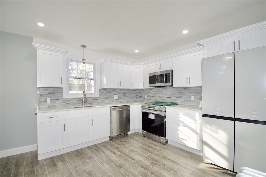 158 Gilbert Avenue Springfield, MA 01119 - Photo 1 of 30 a large kitchen with cabinets wooden floor and stainless steel appliances
