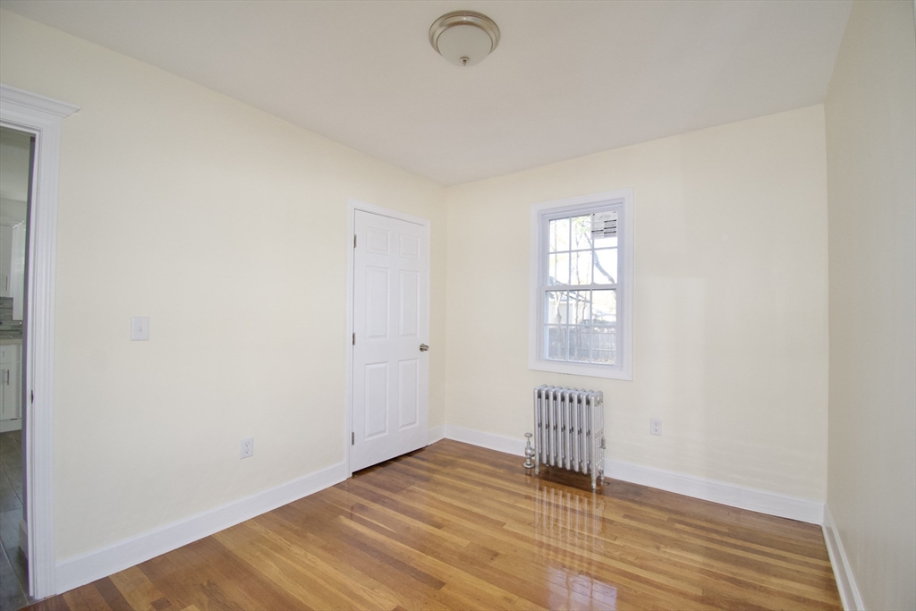 158 Gilbert Avenue Springfield, MA 01119 - Photo 13 of 30 a view of an empty room with wooden floor and a window