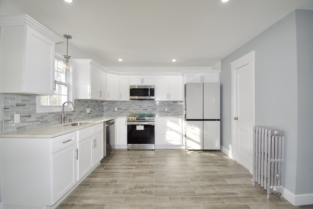158 Gilbert Avenue Springfield, MA 01119 - Photo 8 of 30 a large kitchen with cabinets stainless steel appliances a sink and a stove