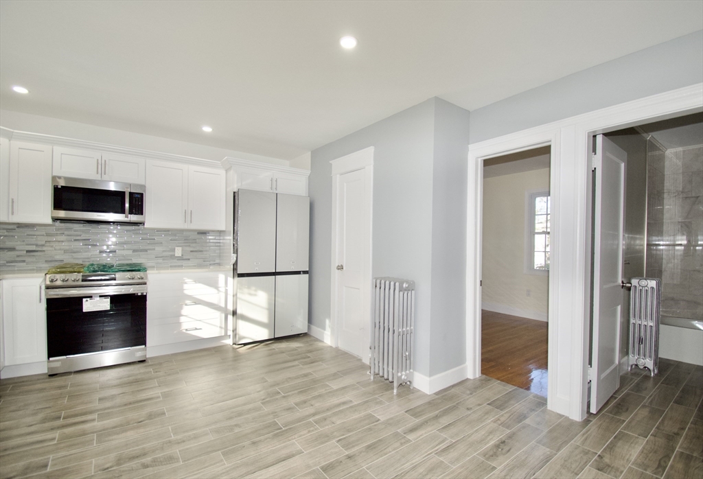 158 Gilbert Avenue Springfield, MA 01119 - Photo 10 of 30 a large kitchen with stainless steel appliances granite countertop a stove and a refrigerator
