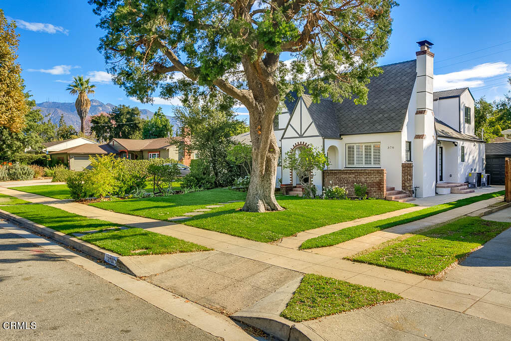 a front view of a house with a yard and trees