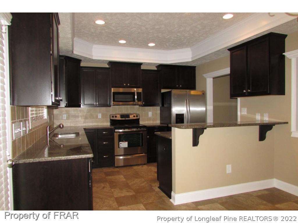 3341 Thrower Road Hope Mills, NC 28348 - Photo 14 of 32 a kitchen with kitchen island a counter space a sink appliances and cabinets