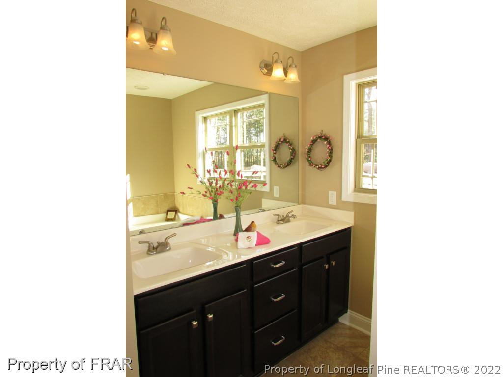 3341 Thrower Road Hope Mills, NC 28348 - Photo 30 of 32 a bathroom with a sink and a mirror