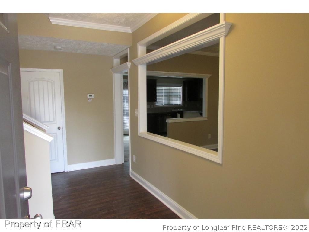 3341 Thrower Road Hope Mills, NC 28348 - Photo 5 of 32 a view of a hallway with wooden floor and a living room