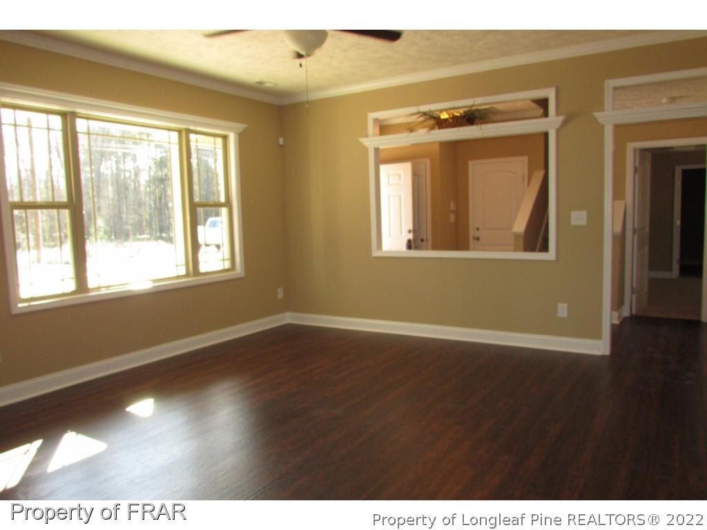 3341 Thrower Road Hope Mills, NC 28348 - Photo 6 of 32 a view of an empty room with wooden floor and a window