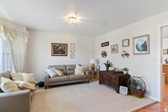 5321 South 3100th Street West Roy, UT 84067 - Photo 24 of 64 Carpeted living area featuring light-colored walls and a classic ceiling light fixture