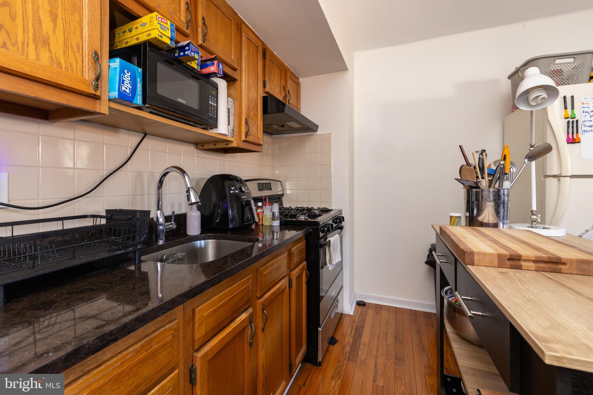 910 Mountain Street Philadelphia, PA 19148 - Photo 14 of 31 a kitchen with granite countertop a sink a stove and cabinets