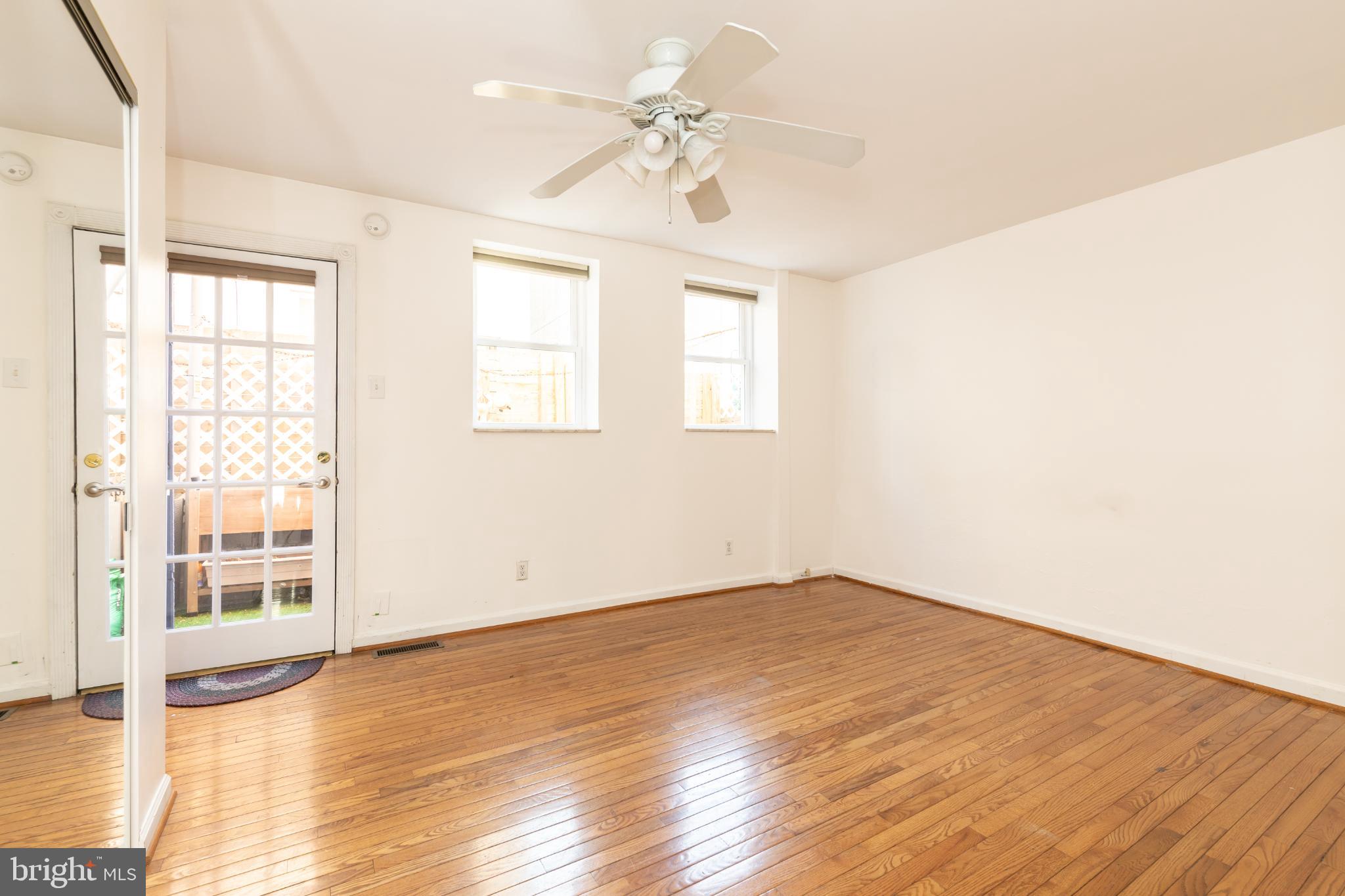 910 Mountain Street Philadelphia, PA 19148 - Photo 7 of 31 an empty room with wooden floor chandelier fan and windows