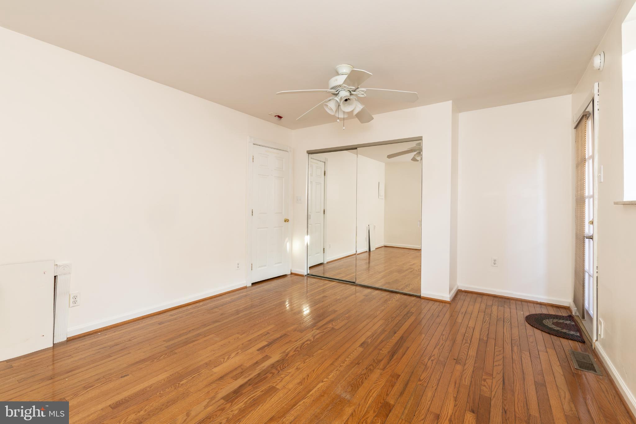 910 Mountain Street Philadelphia, PA 19148 - Photo 8 of 31 an empty room with wooden floor chandelier fan and windows