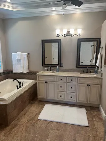 a spacious bathroom with a granite countertop double vanity sink a mirror and a