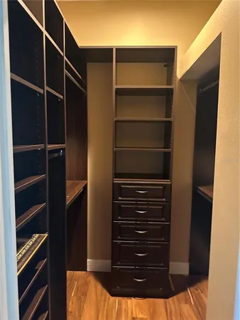 a view of walk in closet with empty racks