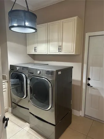 a utility room with cabinets and washer
