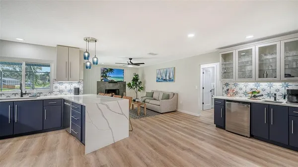 a large living room with stainless steel appliances granite countertop a couch and cabinets