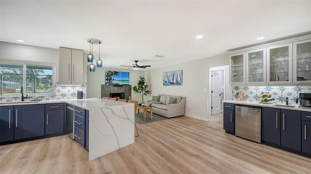 a large living room with stainless steel appliances granite countertop a couch and cabinets