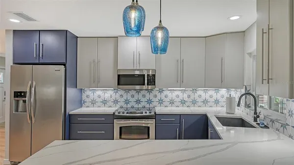 a kitchen with kitchen island granite countertop stainless steel appliances and wooden cabinets