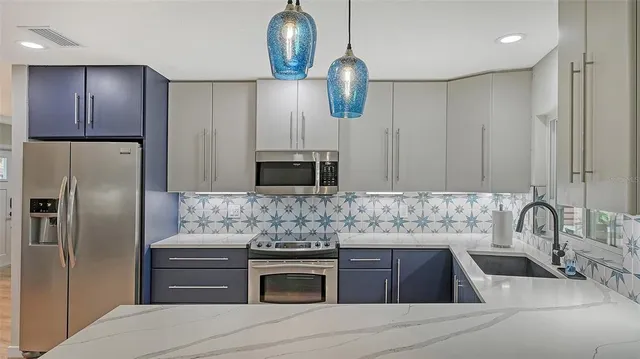 a kitchen with kitchen island granite countertop stainless steel appliances and wooden cabinets