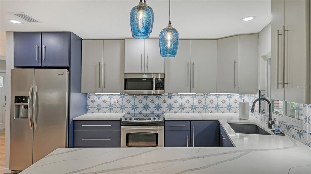 3924 Helene Street Sarasota, FL 34233 - Photo 25 of 53 a kitchen with kitchen island granite countertop stainless steel appliances and wooden cabinets