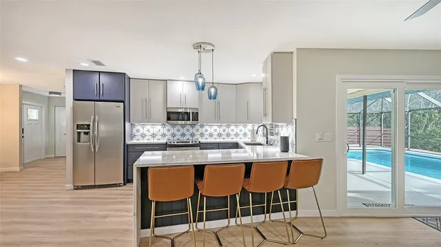 a kitchen with kitchen island granite countertop a refrigerator and wooden cabinets