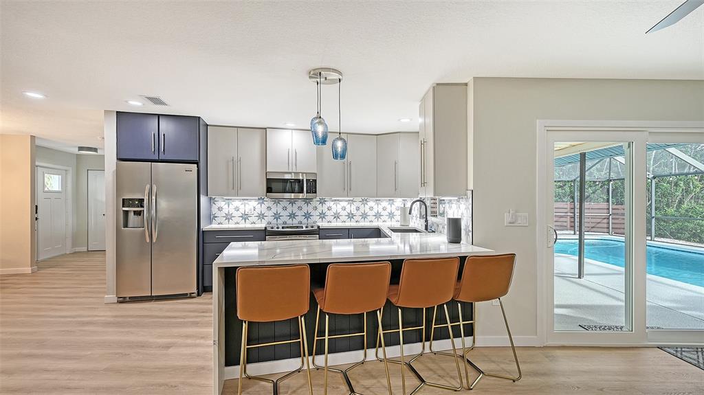 3924 Helene Street Sarasota, FL 34233 - Photo 27 of 53 a kitchen with kitchen island granite countertop a refrigerator and wooden cabinets