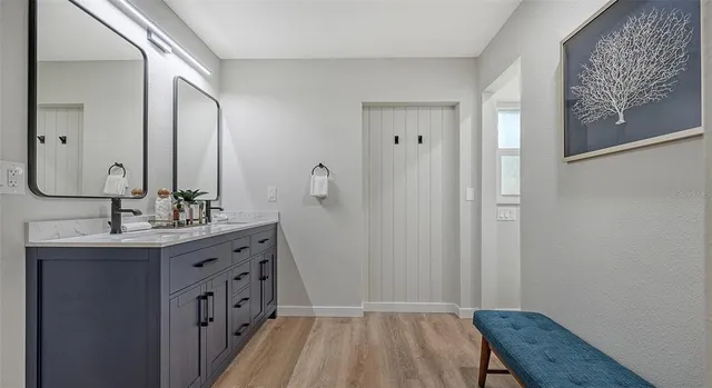 a bathroom with a sink a mirror a vanity and a toilet