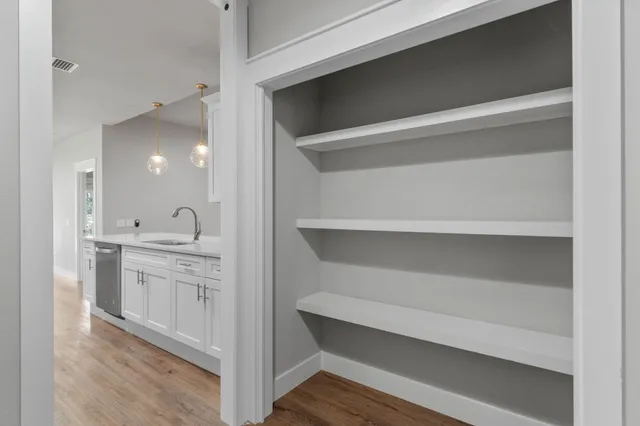 an empty room with wooden floor and ceiling fan