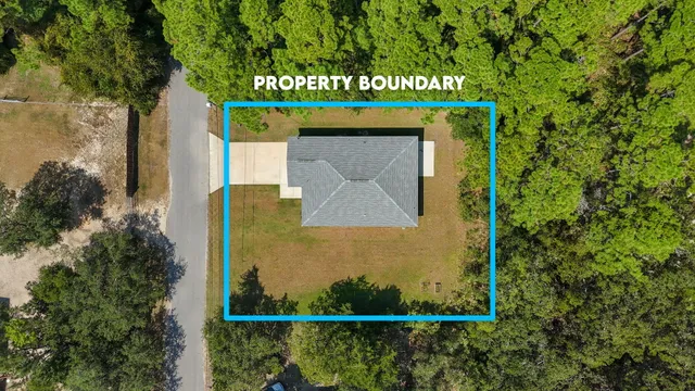 an aerial view of a residential houses with yard