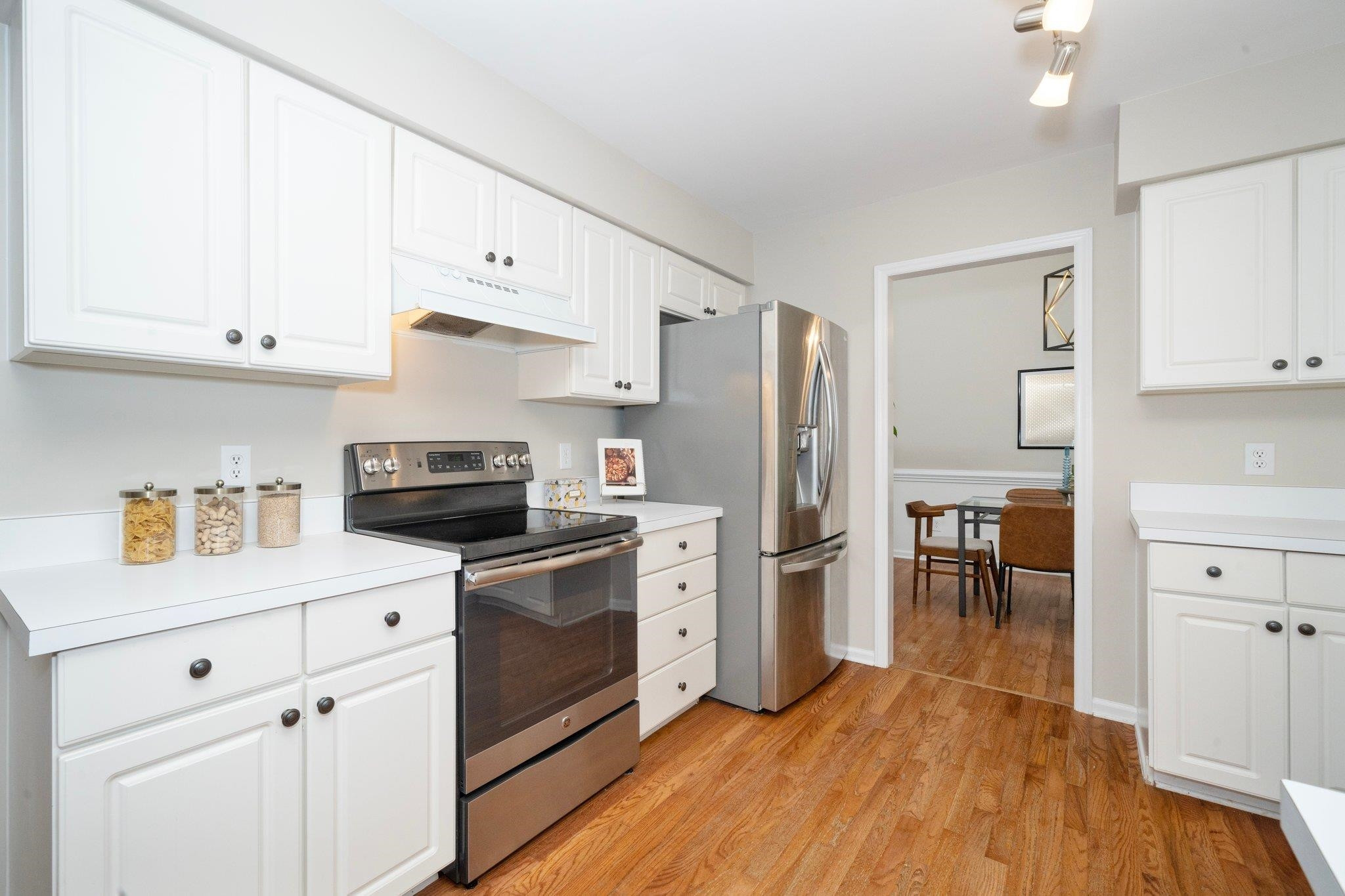 8813 Harps Mill Road Raleigh, NC 27615 - Photo 12 of 28 a kitchen with white cabinets and stainless steel appliances