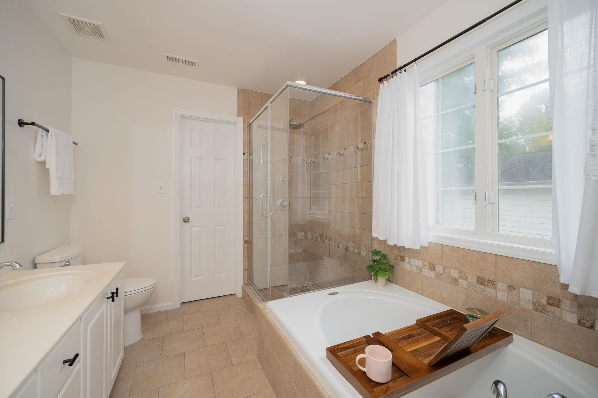 8813 Harps Mill Road Raleigh, NC 27615 - Photo 18 of 28 a bathroom with a tub shower and sink