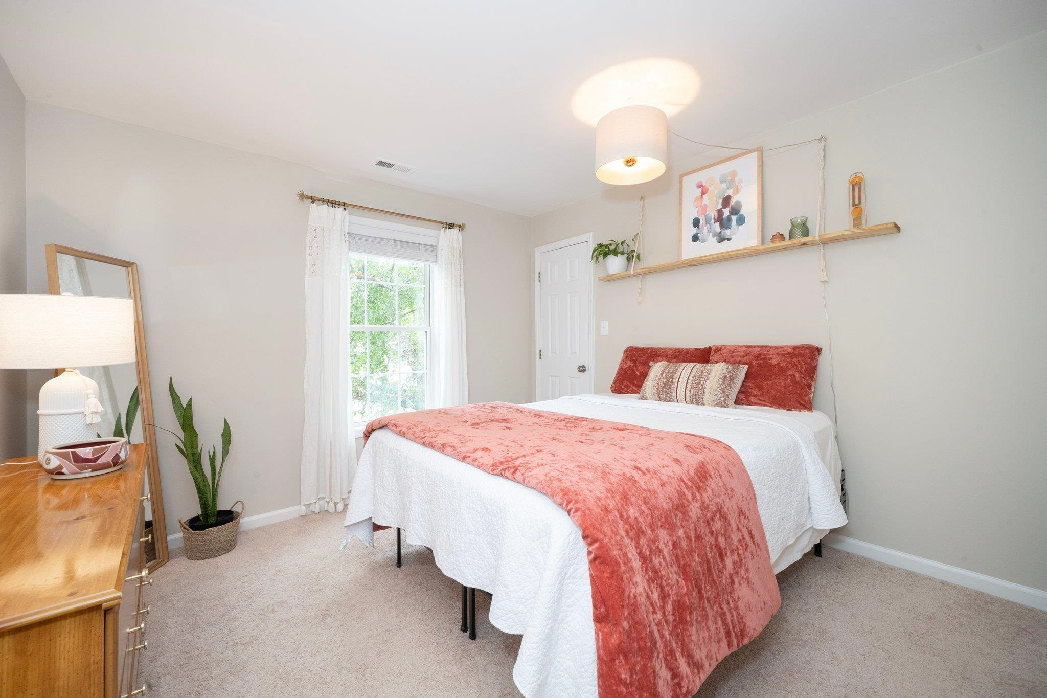 8813 Harps Mill Road Raleigh, NC 27615 - Photo 19 of 28 a bedroom with a bed and a chandelier