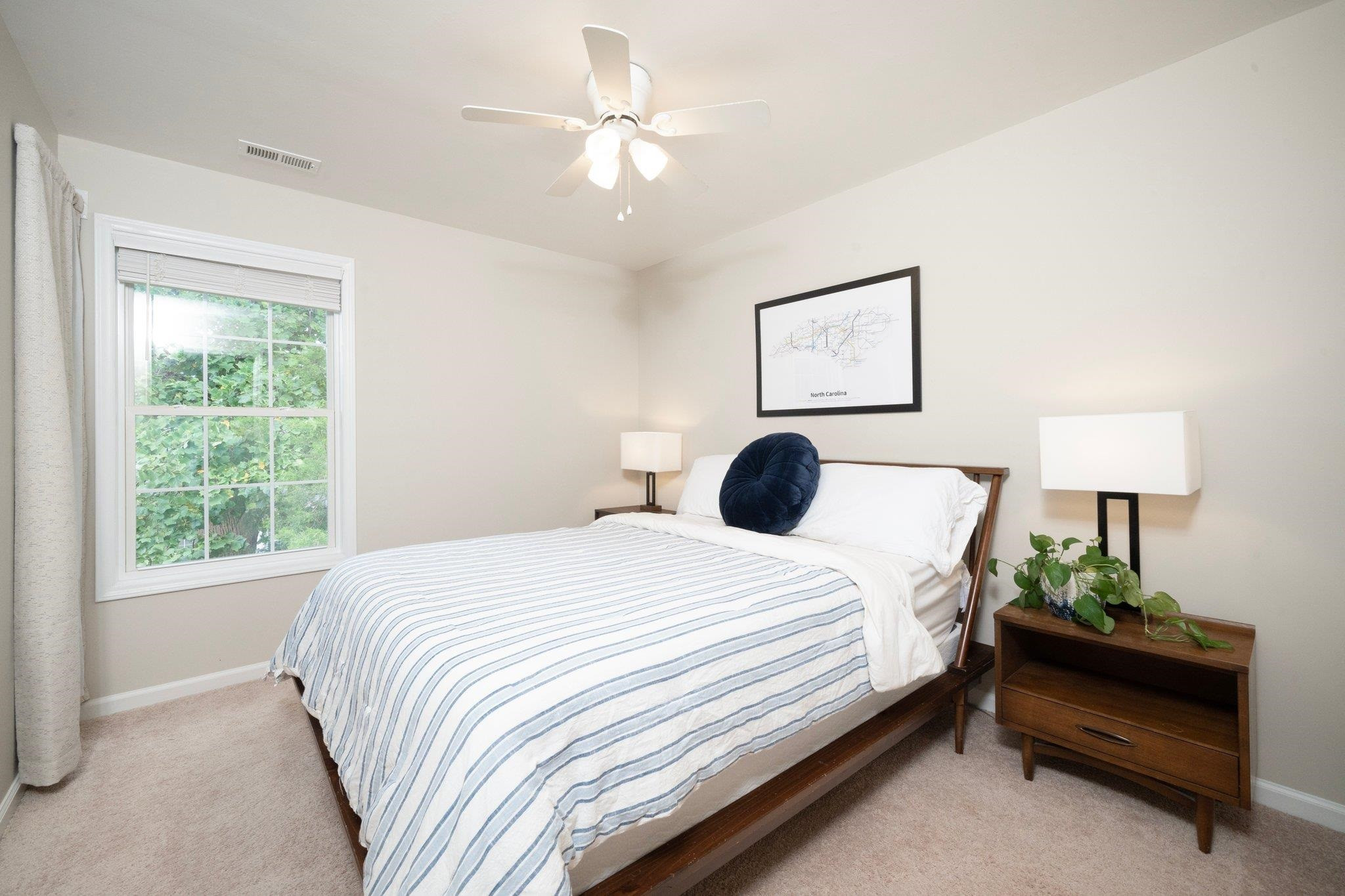 8813 Harps Mill Road Raleigh, NC 27615 - Photo 20 of 28 a bedroom with a bed painting on wall and a window
