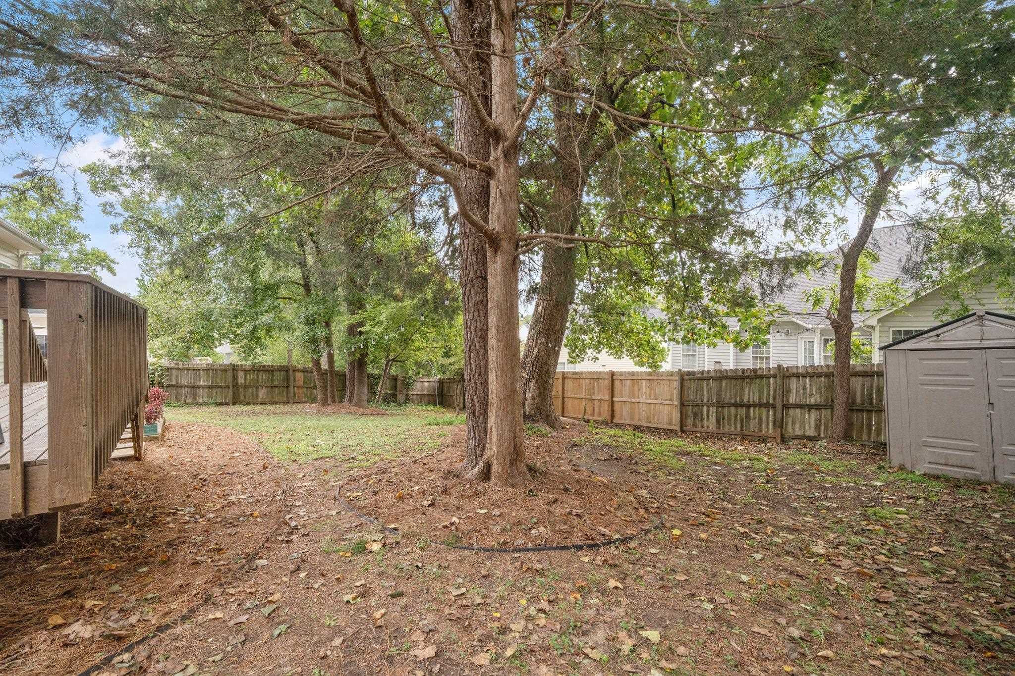 8813 Harps Mill Road Raleigh, NC 27615 - Photo 26 of 28 a view of a backyard with large trees and a barn