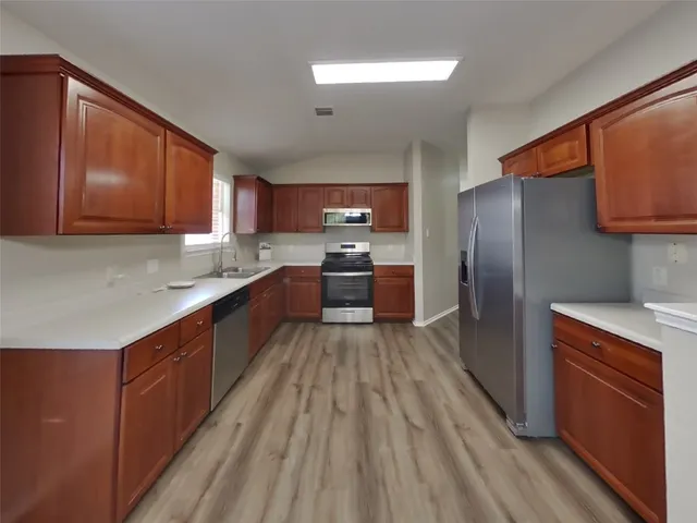 a kitchen with wooden cabinets and stainless steel appliances