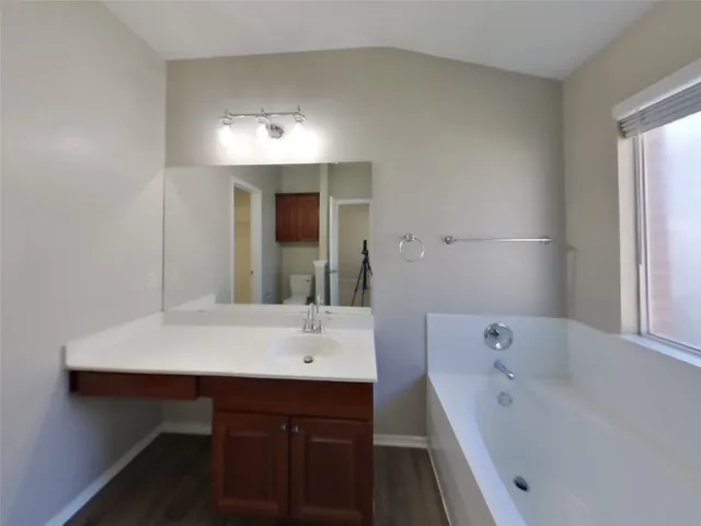 a bathroom with a tub sink and mirror